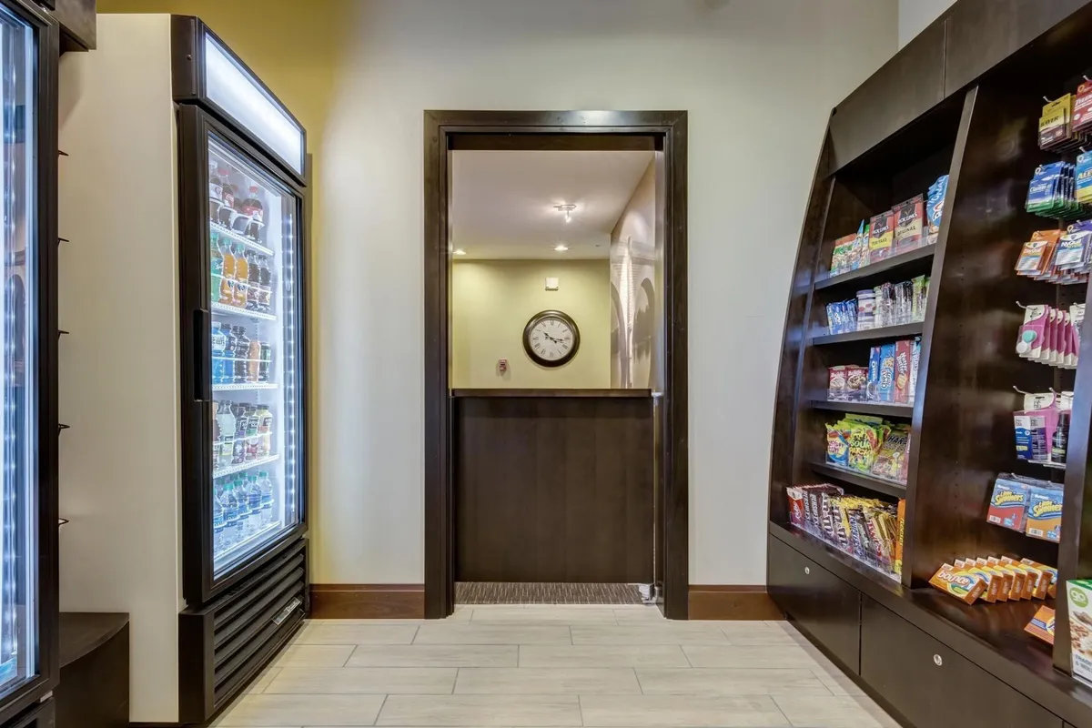 The image features a display refrigerator and snack shelves, offering guests a variety of quick bites and refreshments. The casual setup conveys convenience and accessibility for snack lovers or late-night cravings.